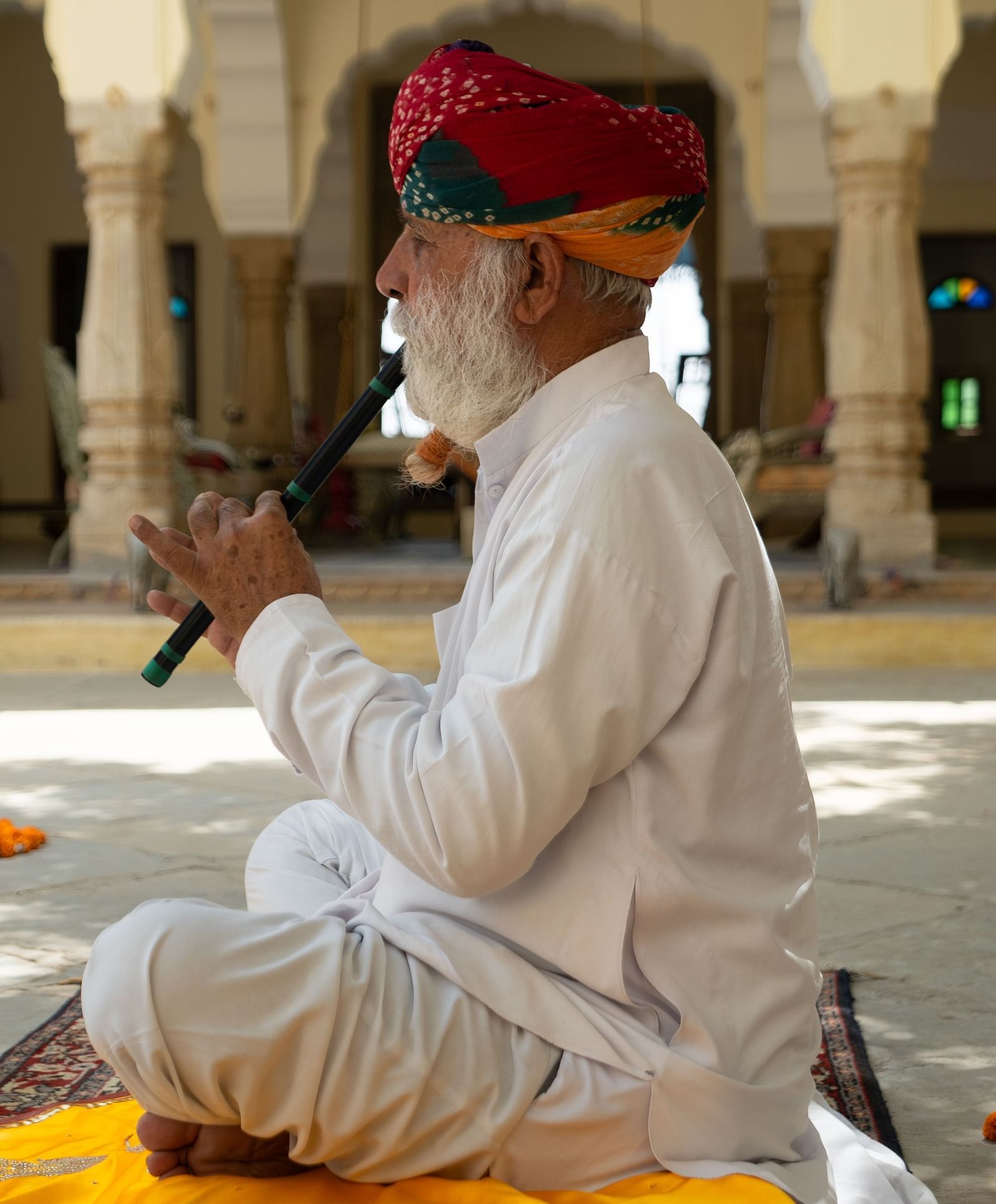 A person playing a flute in the courtyard of The Umaid Vilas, Jaipur