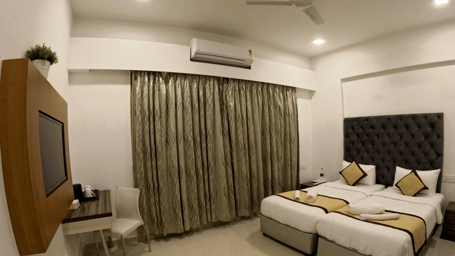 A picture of a bedroom at Sahil Exotica with twin beds and work desk