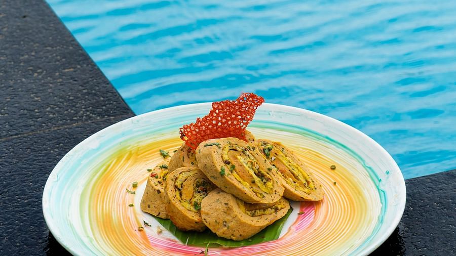 Gourmet chicken dish plated with sauce near a water backdrop.