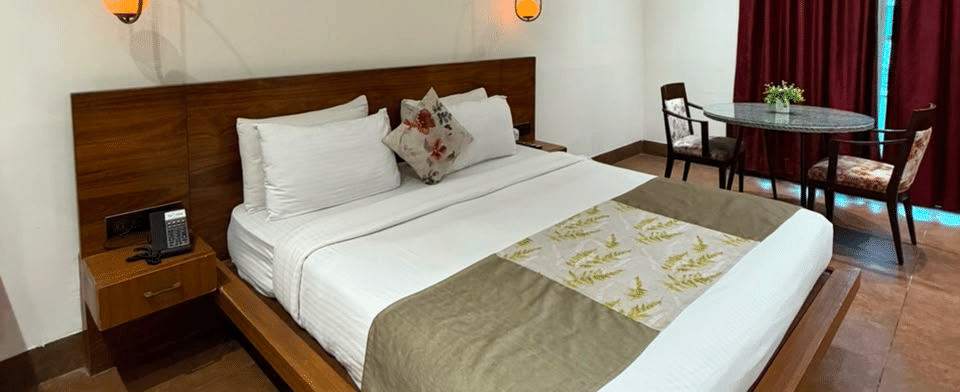 Club Premium Room, Bed and seating with garden-facing drapes
