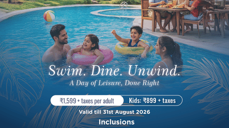 A promotional poster of Aamaghati Wildlife Resort showing families enjoying a swimming pool with children playing in inflatable rings while adults relax nearby, with a poolside dining setup and villa style buildings in the background.