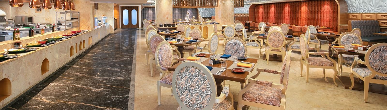 A lavish buffet area with artistic ceiling designs and refined seating arrangements at our restaurant in Mahabalipuram - Kaldan Samudhra Palace