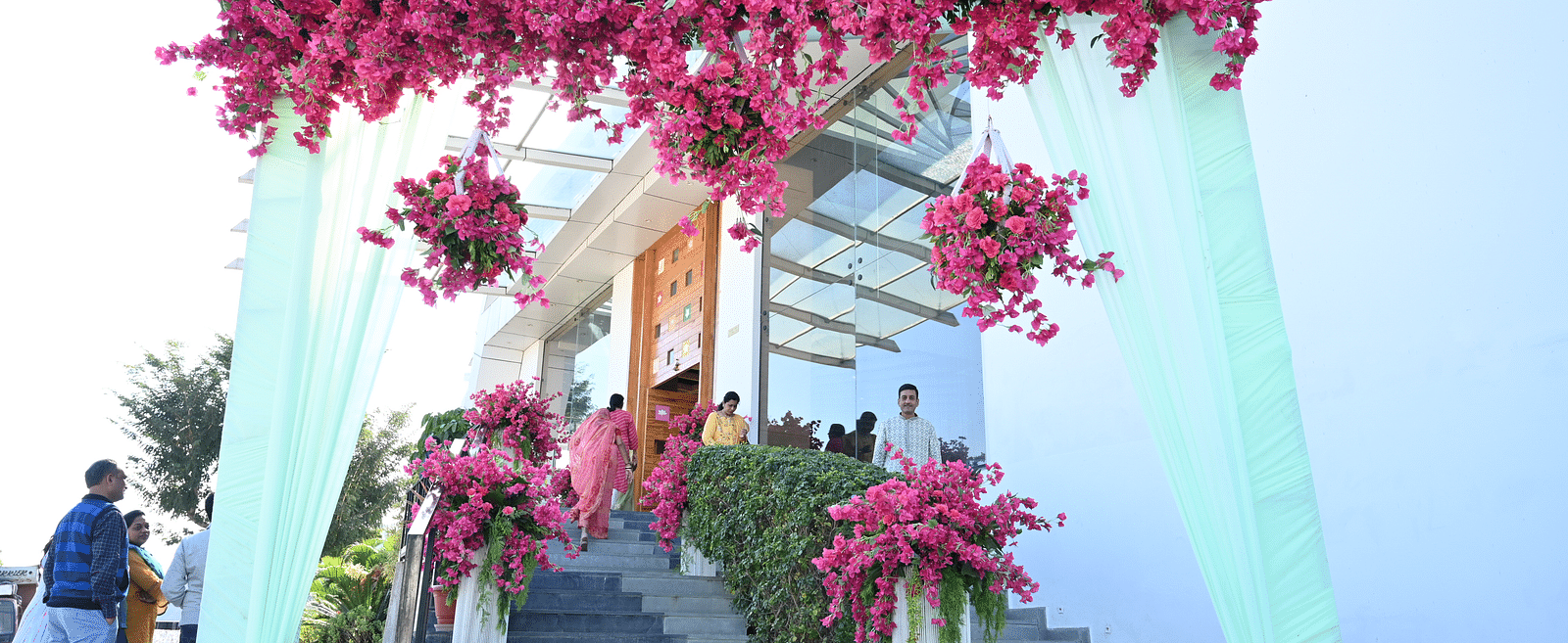 Pink floral arrangements with drapes decorated in front of a building -  Via Lakhela Resort & Spa