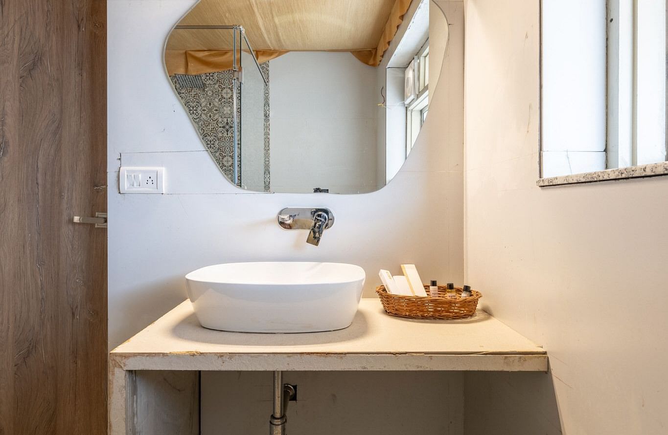 A basin with a mirror placed above it at Valley by Grassfield.