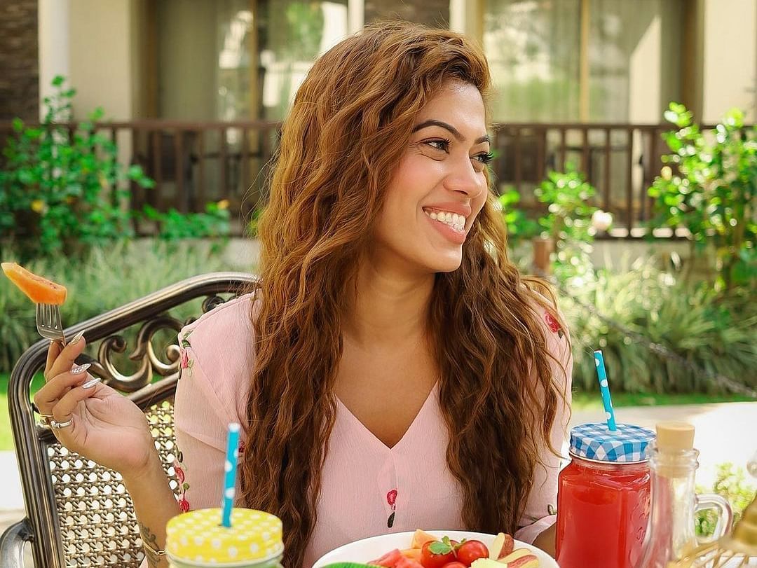 A woman looks happy as she savours her food - Rhythm Lonavala