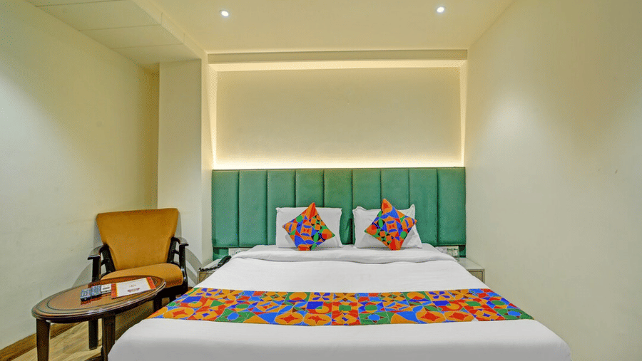 Modern hotel room with twin beds, colorful accents and ambient lighting at Hotel Maurya, Bhopal.