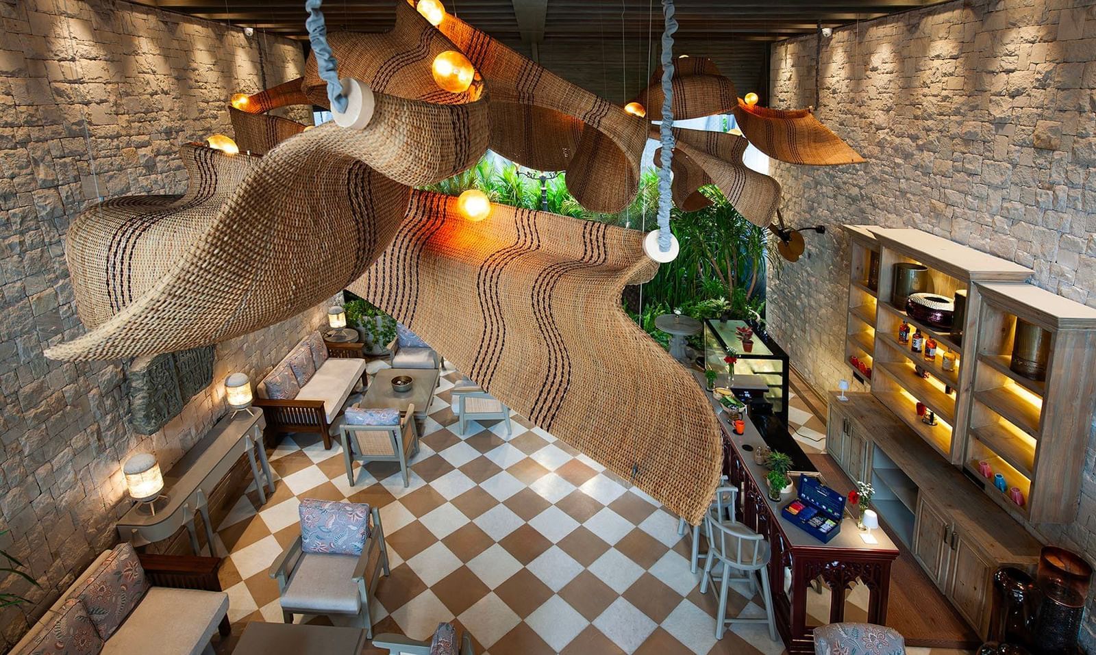A top-angle shot featuring the unique chandelier hanging from the ceiling above the Suenos de Cafe at The Evren, Vagator.