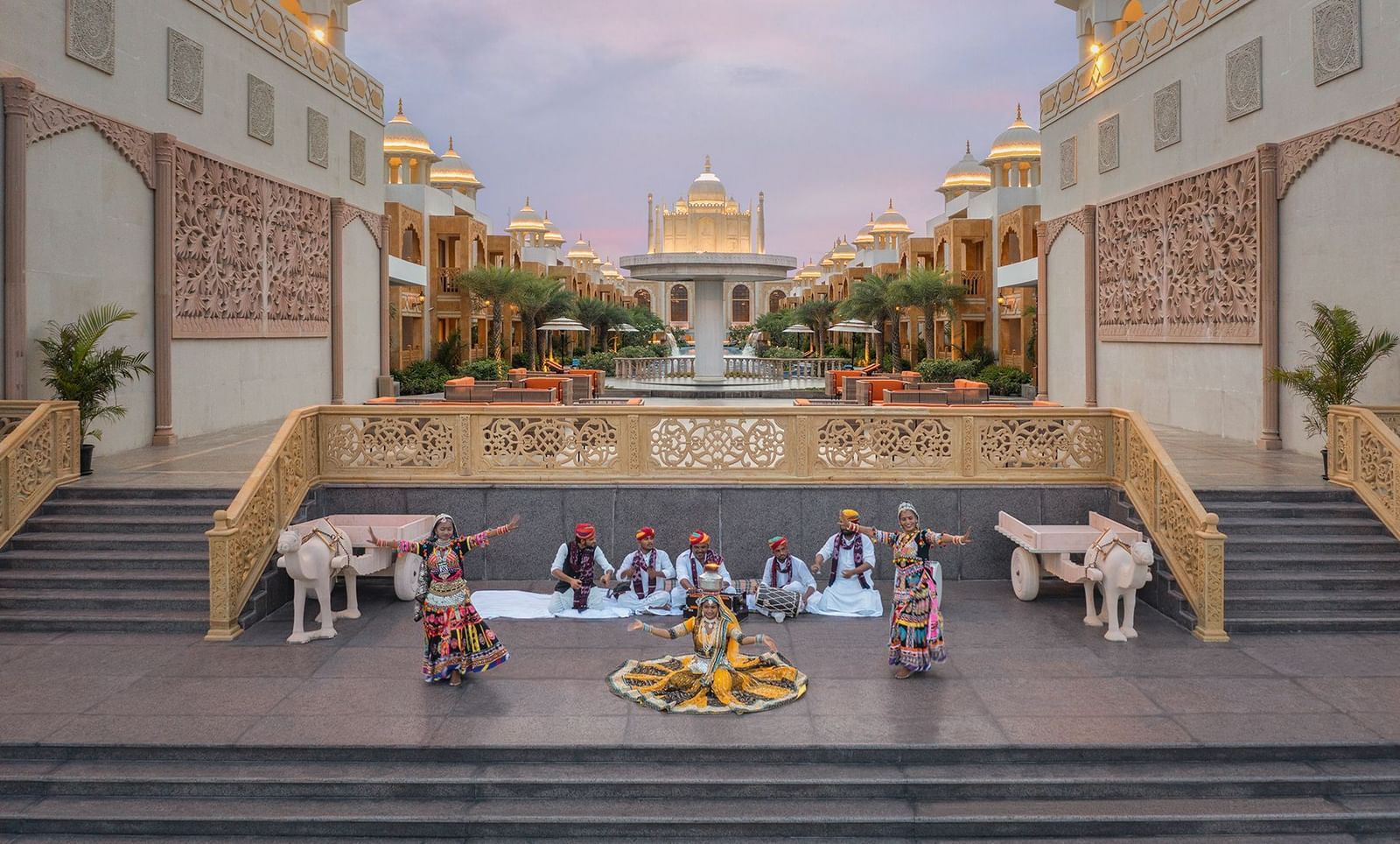 Two women performing the traditional rajasthani dance with musician playing instruments behind them - Kaldan Samudhra Palace