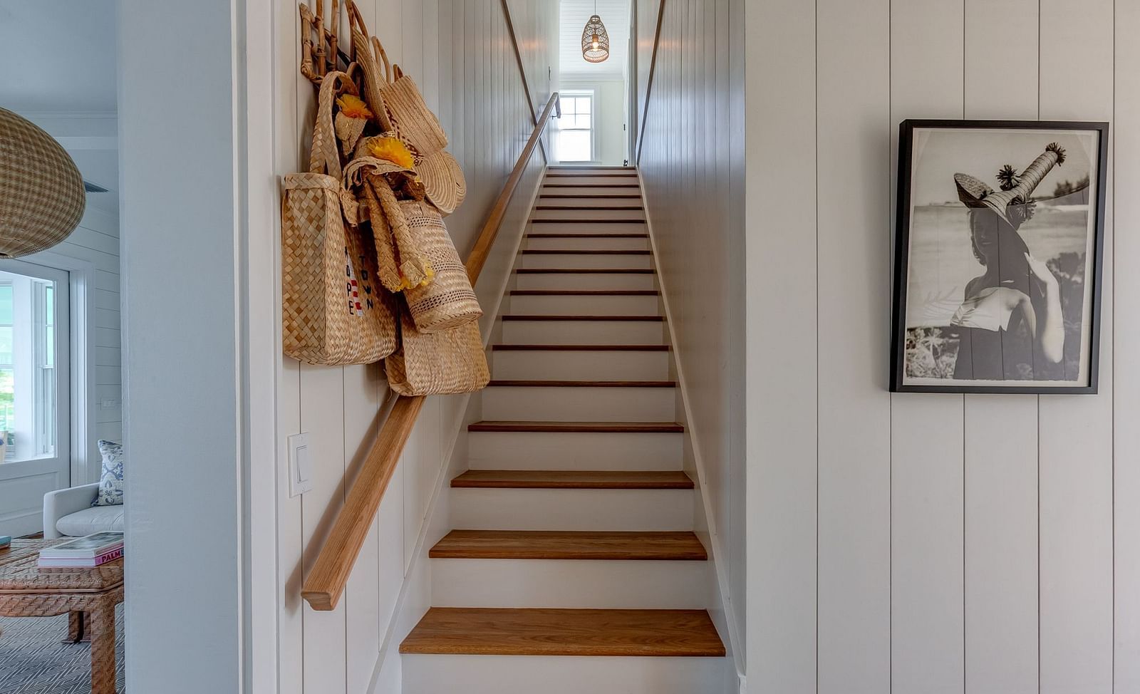 Wooden staircase with framed artwork and decorative hanging items | Abaco Inn