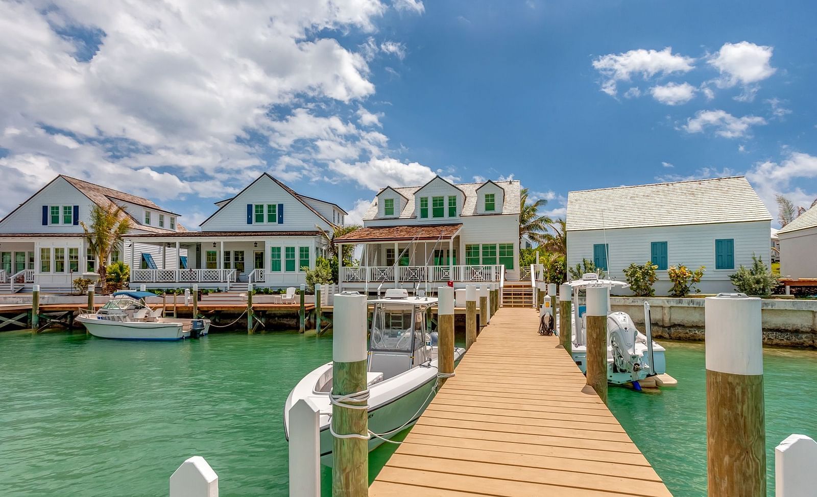 Multiple waterfront villas with private docks along a calm bay with clear skies | Abaco Inn