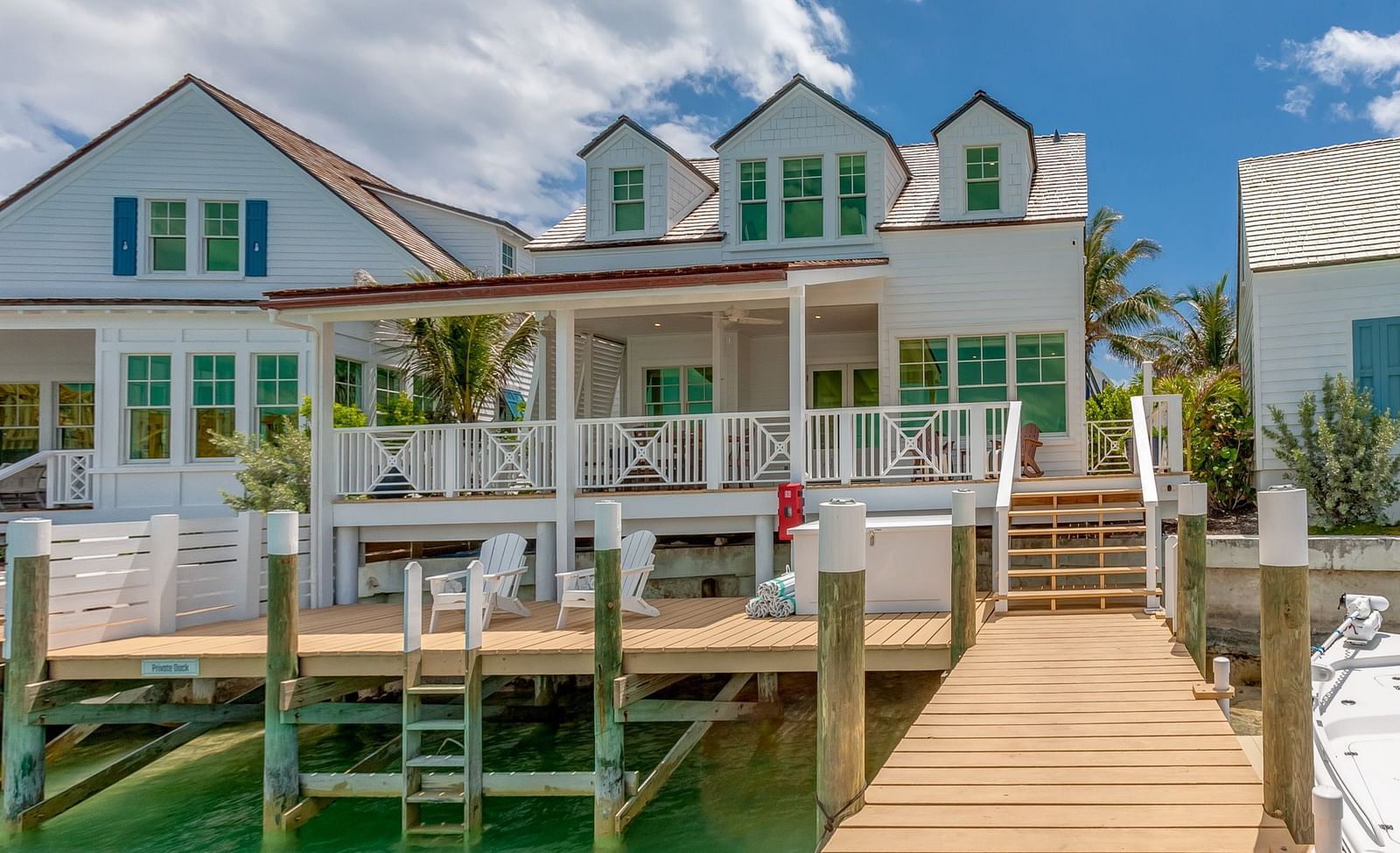 Waterfront villa with a private dock extending over turquoise waters under a blue sky | Abaco Inn