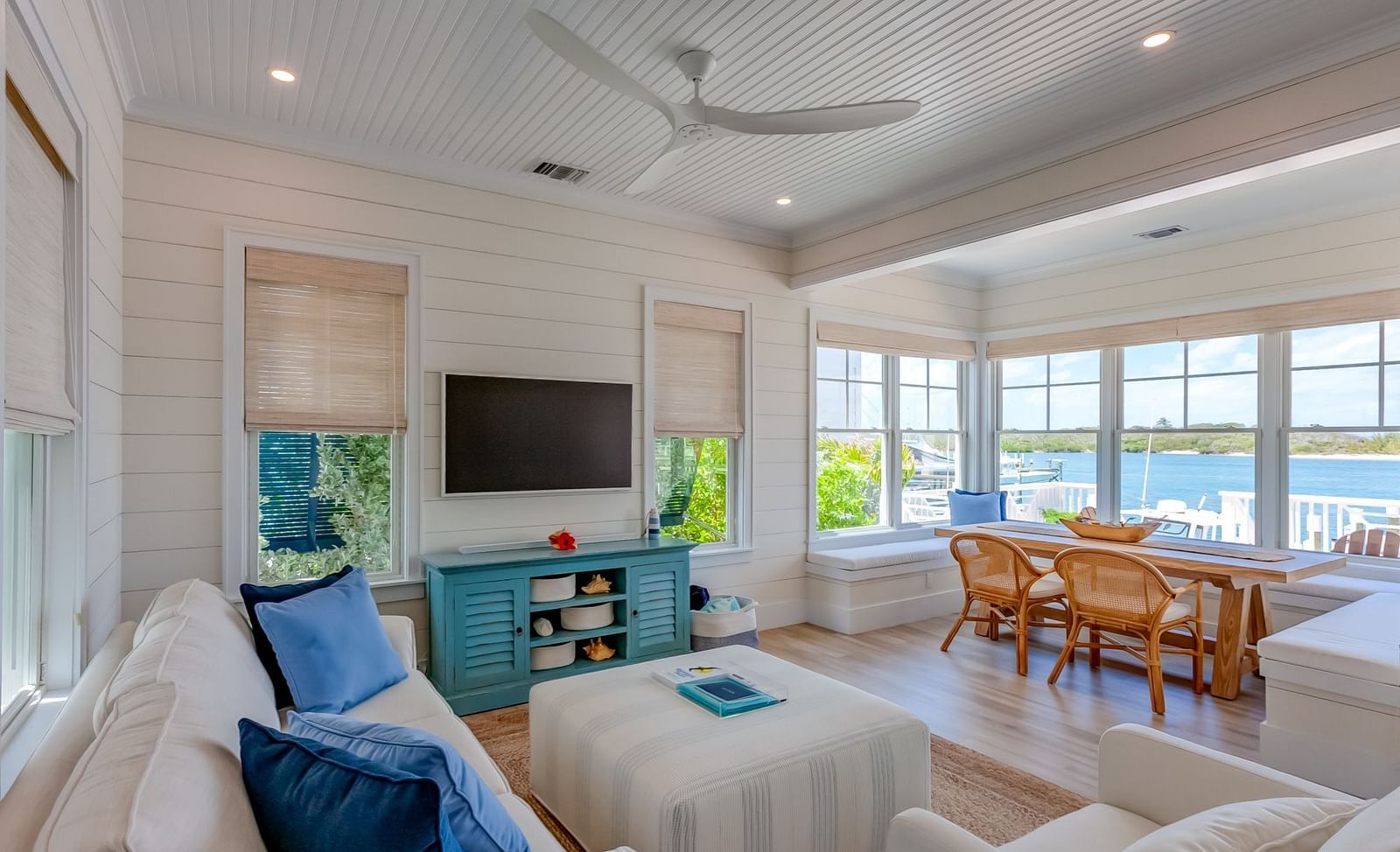 Bright furnished living room with a flat-screen TV and large windows | Abaco Inn