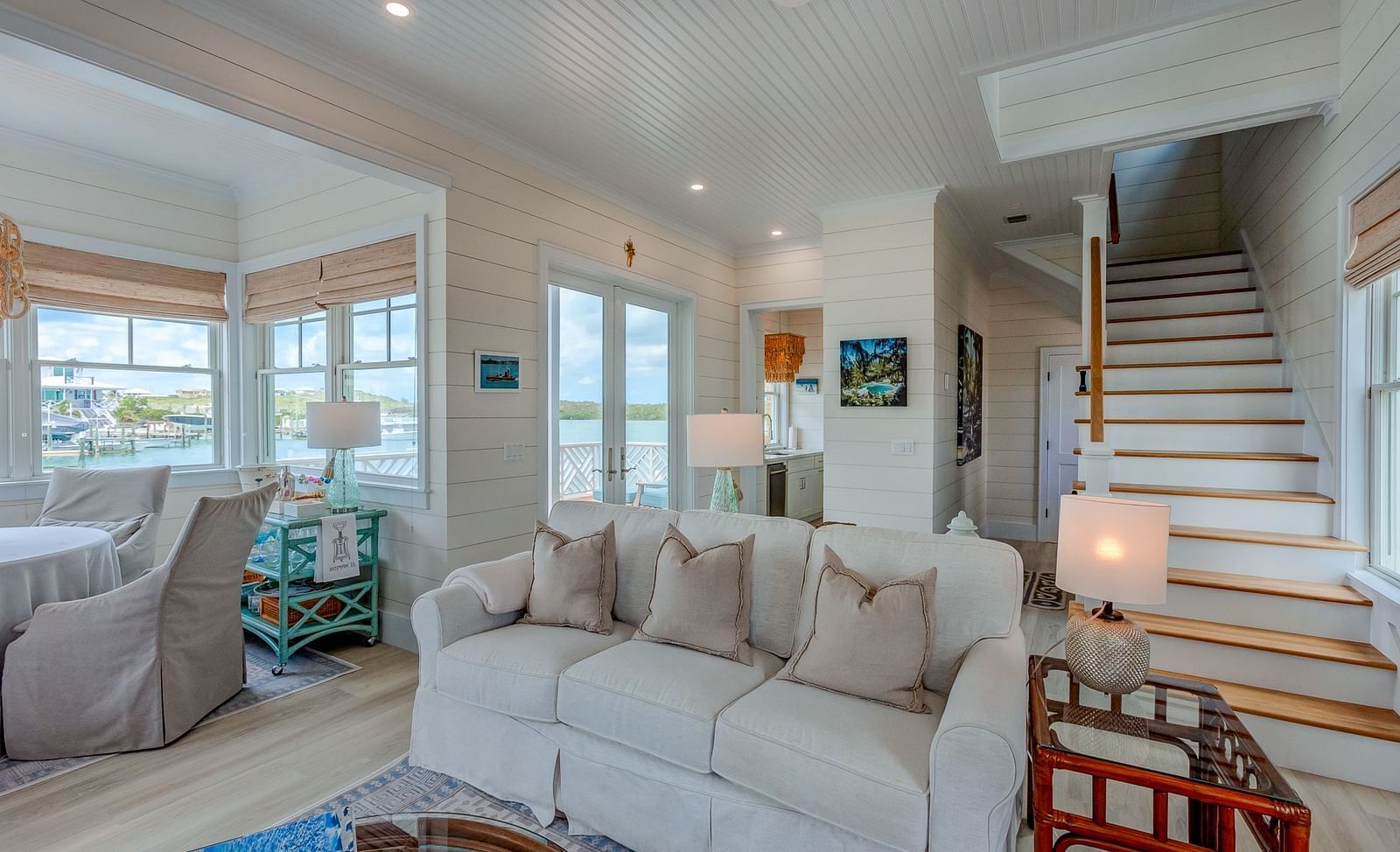 Living room with a large sectional sofa, chairs, and a staircase | Abaco Inn