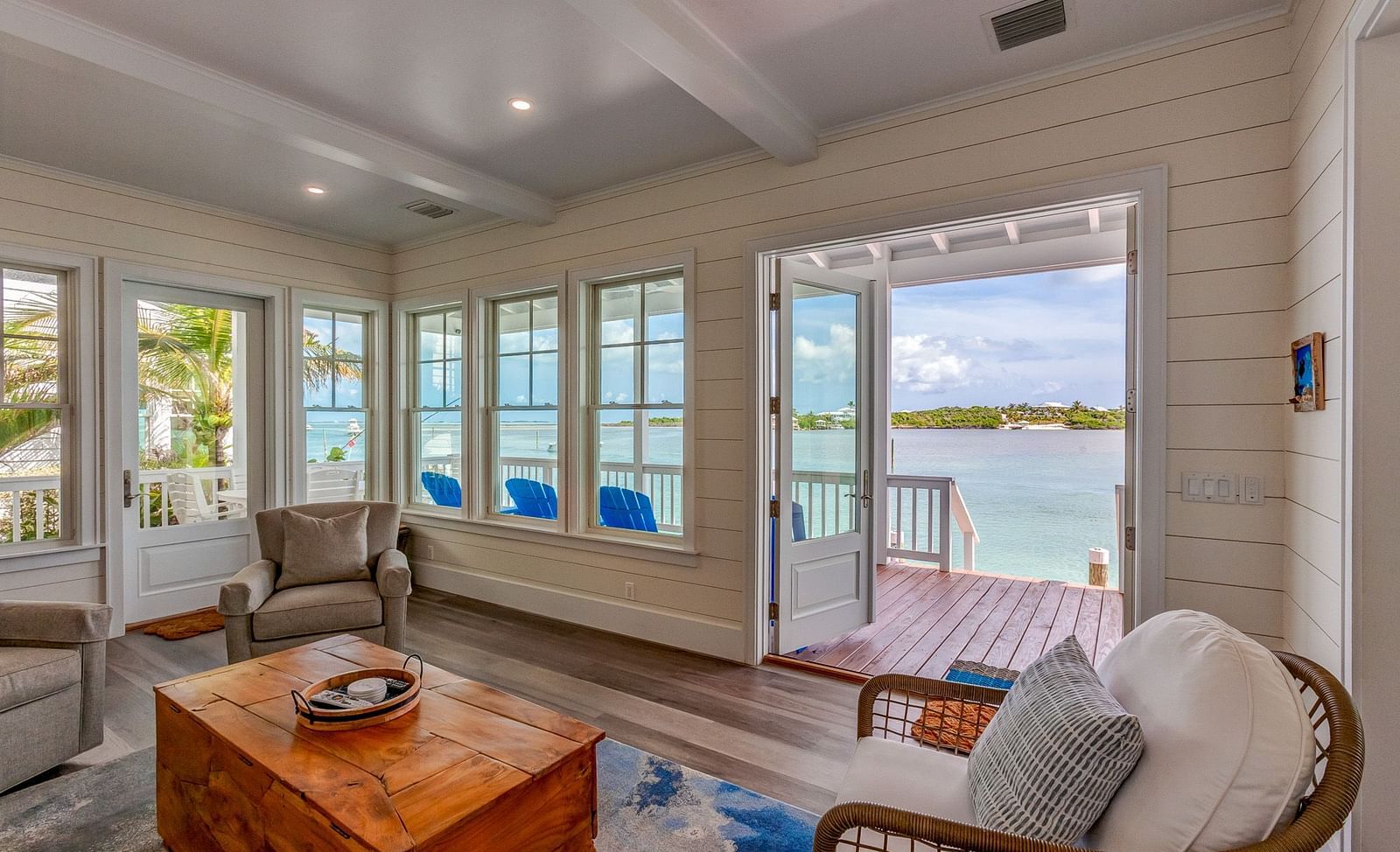 Living room with wicker chairs, a wooden coffee table, and a waterfront view | Abaco Inn