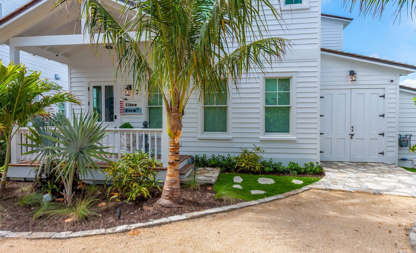 Facade of a white house with palm trees at Abaco Inn.