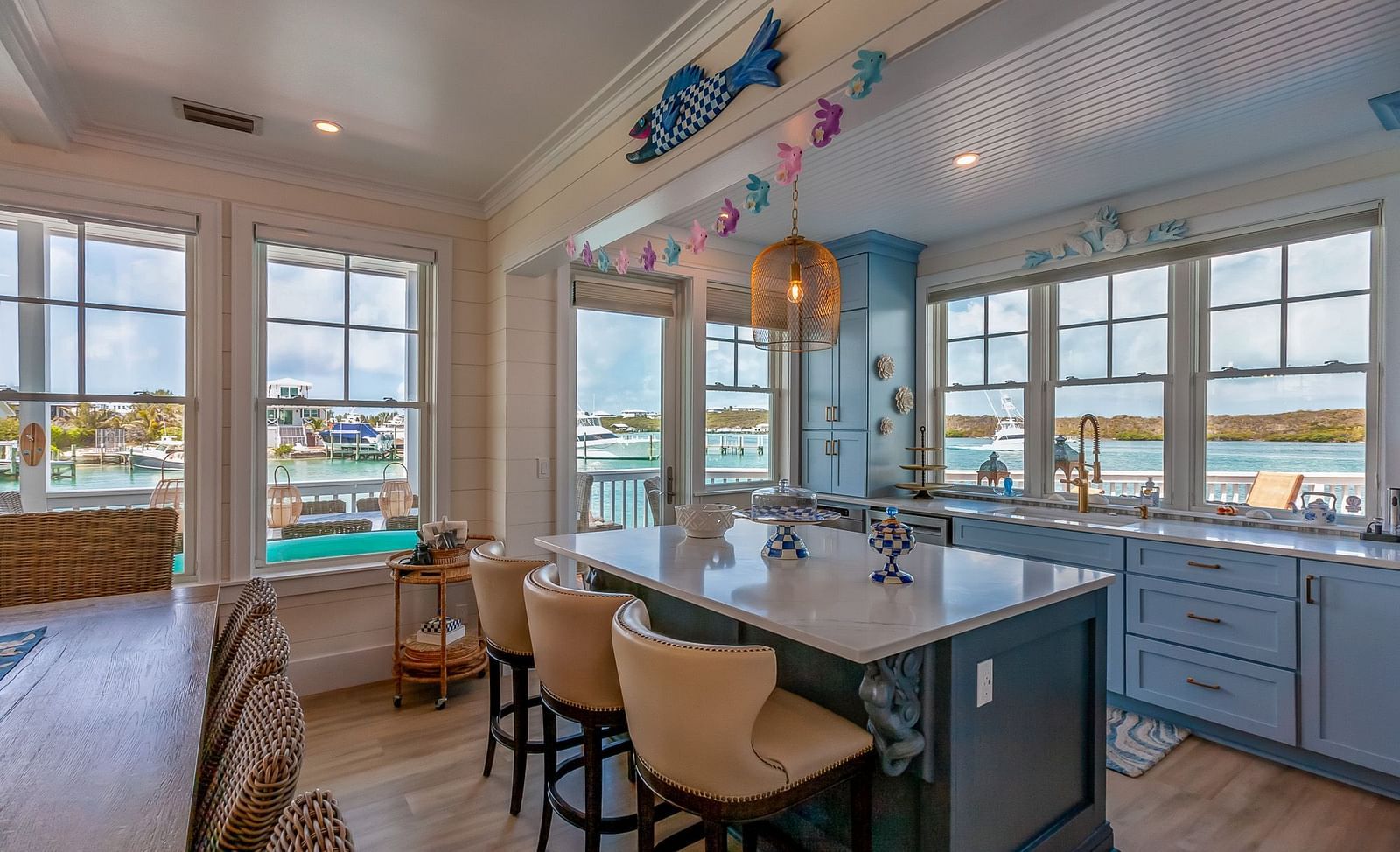 A bright and spacious kitchen with marble top table, chairs and windows with the sea view at Abaco Inn.