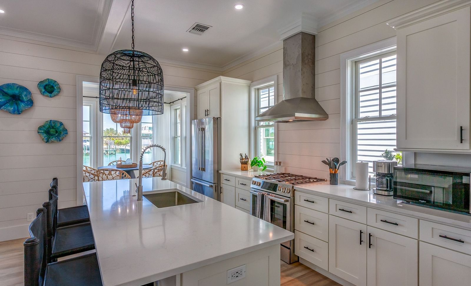 well lit Spacious kitchen with marble top table, chairs, cupboards, fridge, oven and a chimney at Abaco Inn.