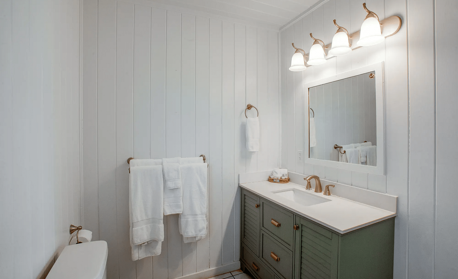 Bathroom with sink, mirror, and towels in a white interior | Abaco Inn