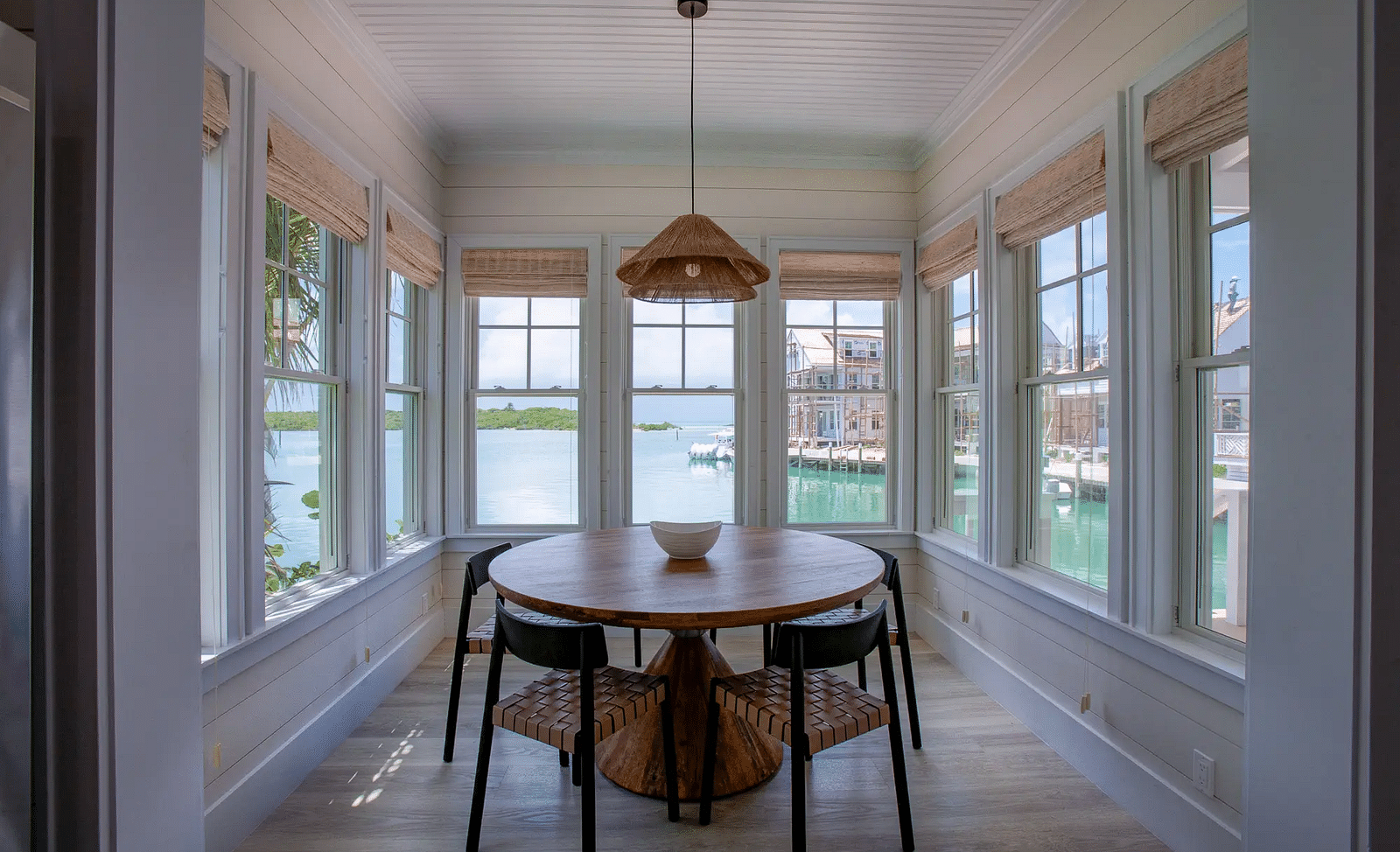 Cozy dining nook with a round table and surrounding windows | Abaco Inn