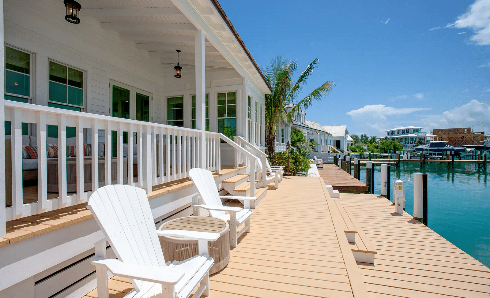 Outdoor deck with white lounge chairs offering waterfront views | Abaco Inn
