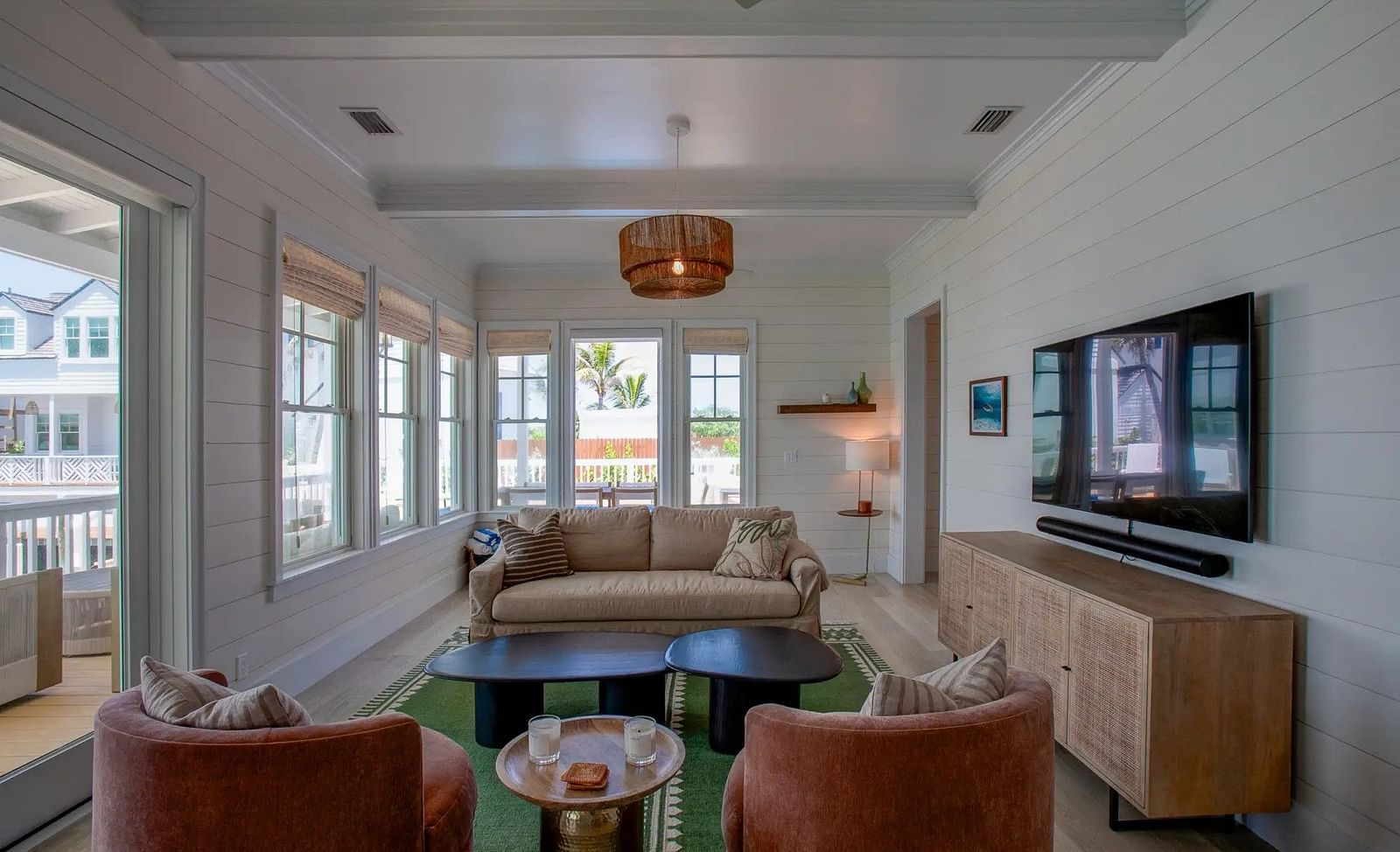 Living room with a sofa set, armchairs, and large windows facing the outdoors | Abaco Inn