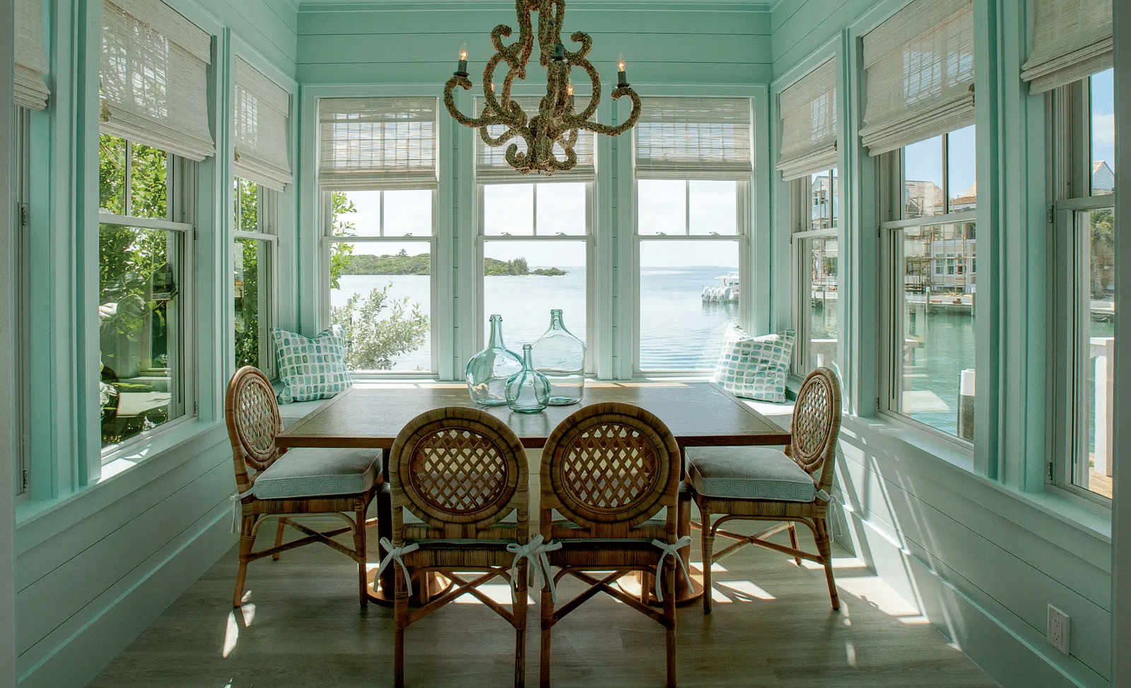 Dining area with a large chandelier and windows offering sea views | Abaco Inn