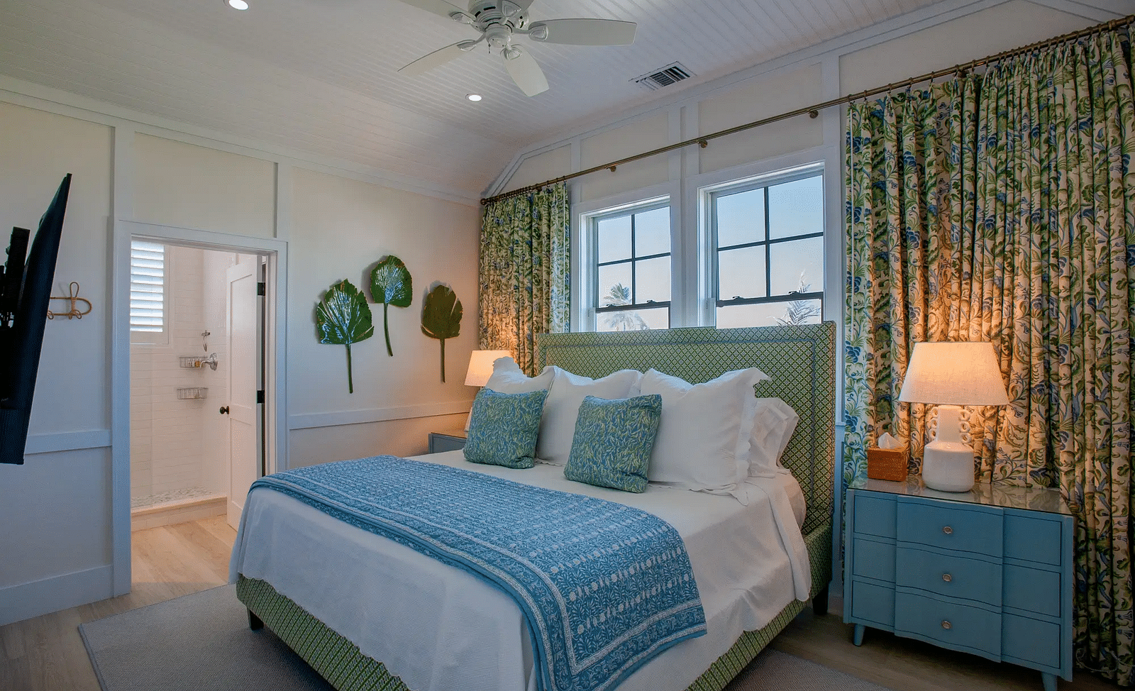 Bedroom with green floral curtains, a blue dresser, and white bedding | Abaco Inn