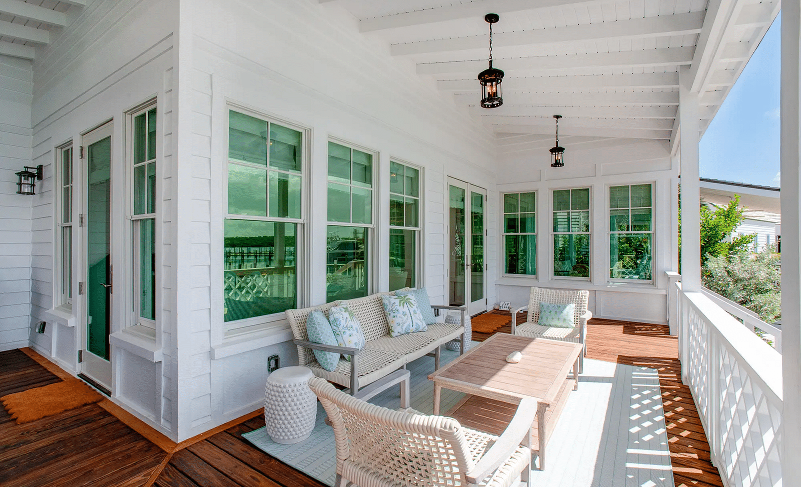Enclosed porch with white wicker furniture and panoramic water views | Abaco Inn