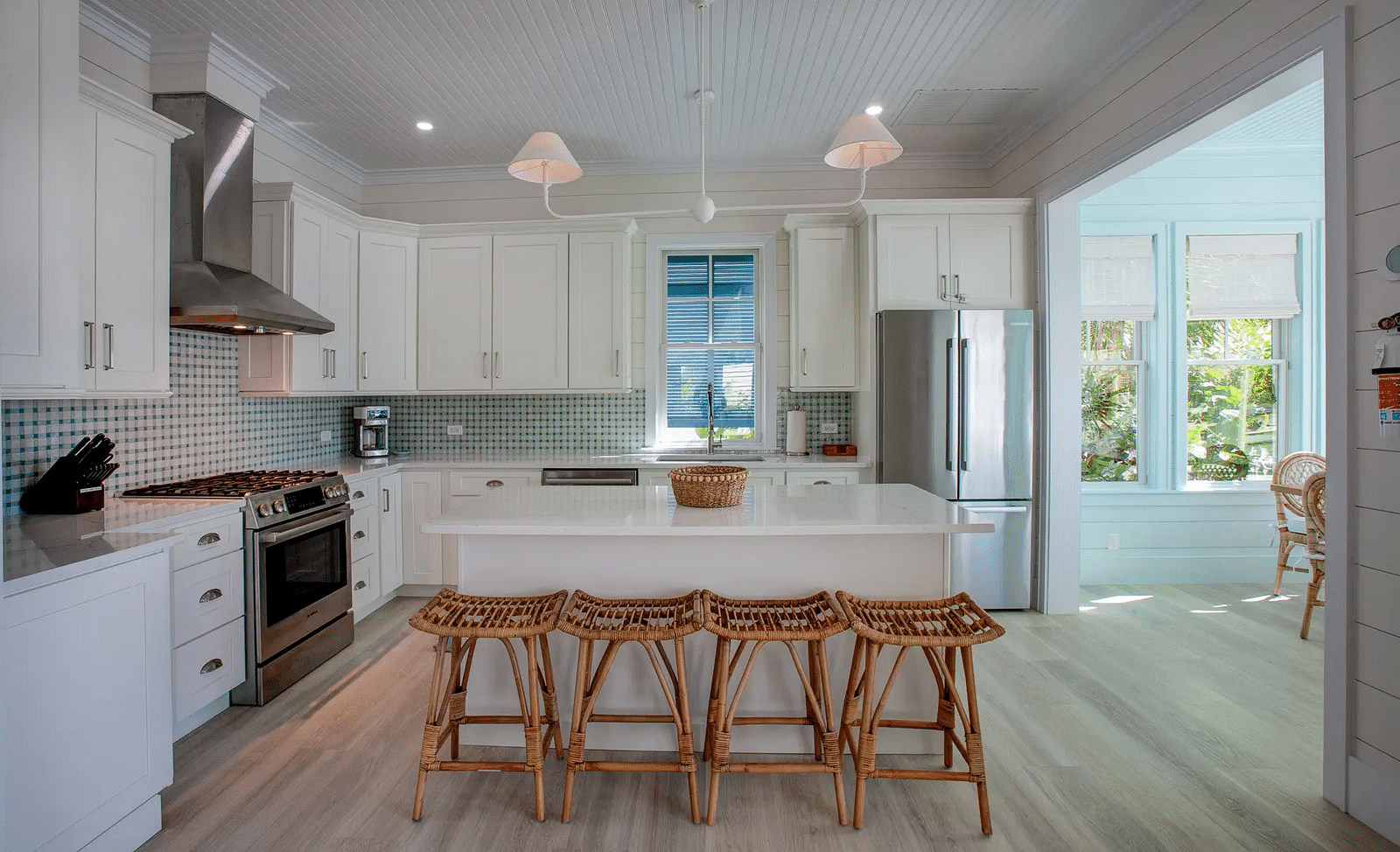 Modern kitchen with white cabinets, island seating, and pendant lights | Abaco Inn