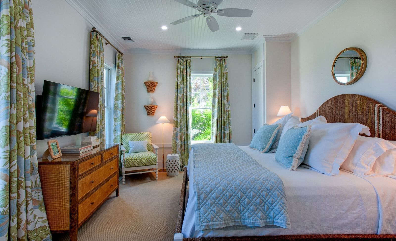 A well-appointed bedroom at Abaco Inn featuring a large bed featuring a headboard, bedside tables with lamps, and a television mounted on a dresser 