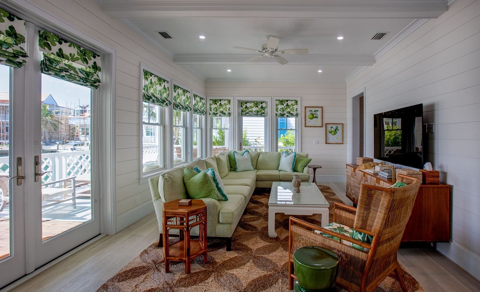 A spacious living room at Abaco Inn featuring multiple windows, comfortable seating arrangements, a television, and decorative elements throughout the well-lit space - Abaco Inn
