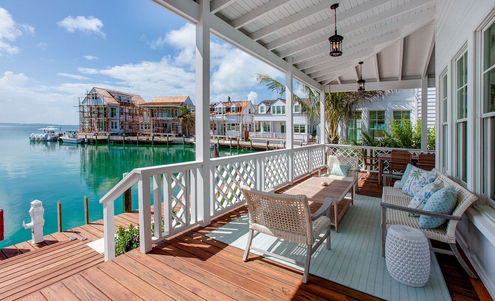 An expansive outdoor deck positioned over water at Abaco Inn, furnished with a dining table and various seating options, offering views of the surrounding area