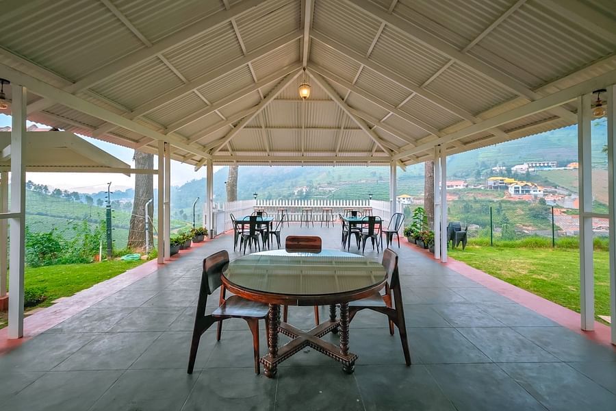 Seating arrangement inside a gazebo with manicured garden on either side - Ibex Stays & Trails, Coonoor (Leewood).