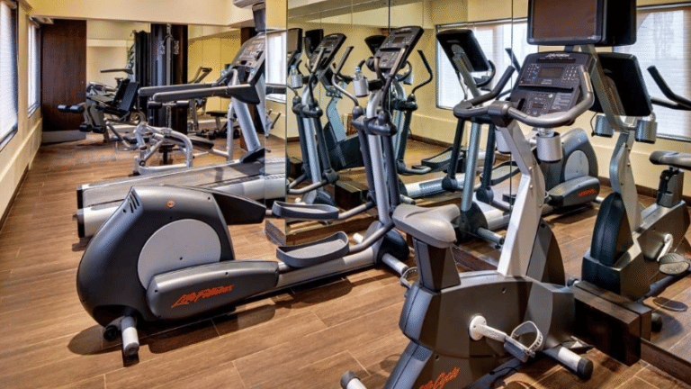 Fitness centre at Goldfinch Bengaluru with multiple stationary bikes, treadmills, ellipticals, and a full mirrored wall.