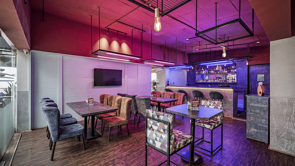 An image of the Bryants Lounge with seating arrangement, and decorative lighting hanging from the ceiling - GReaT Trails Kodaikanal By GRT Hotels
