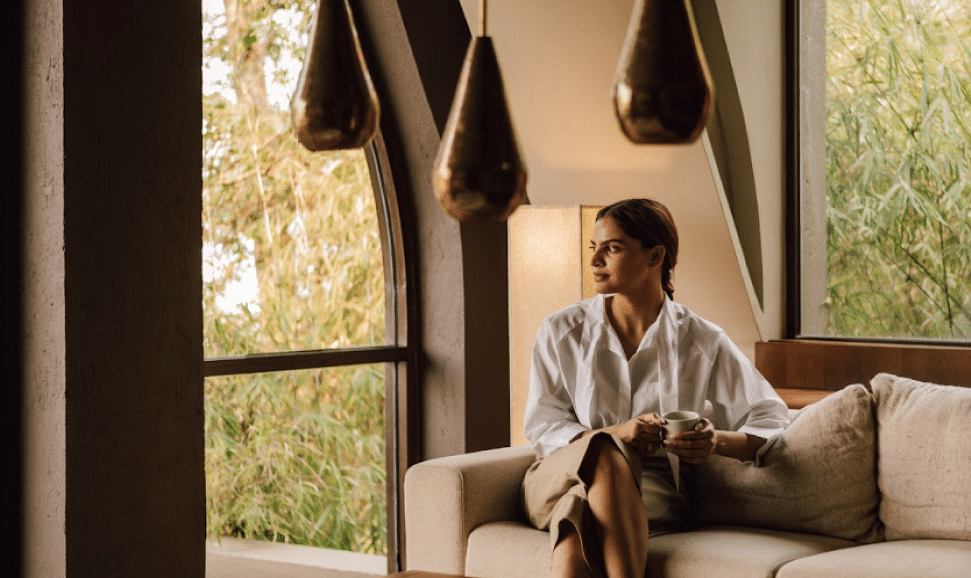 A lady sitting on a sofa looking outside the window | Kavya Resort and Spa, Nagarkot