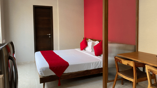 well-furnished room with a king size bed, work desk and chair and refrigerator