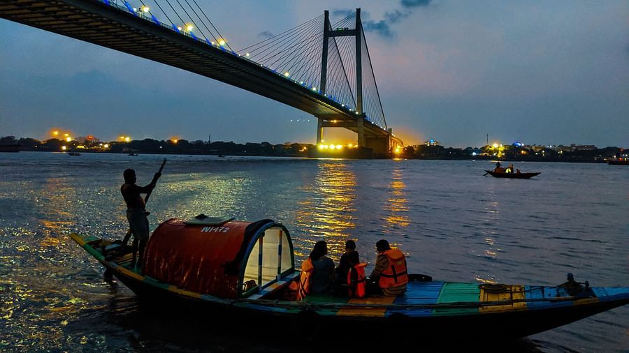 Howrah bridge with a boat passing by in Hooghly river