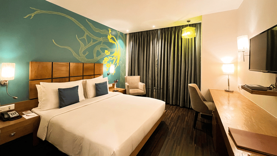 Deluxe Room at The Beatle Hotel, Powai, featuring a modern design with a peacock-themed wall mural.
