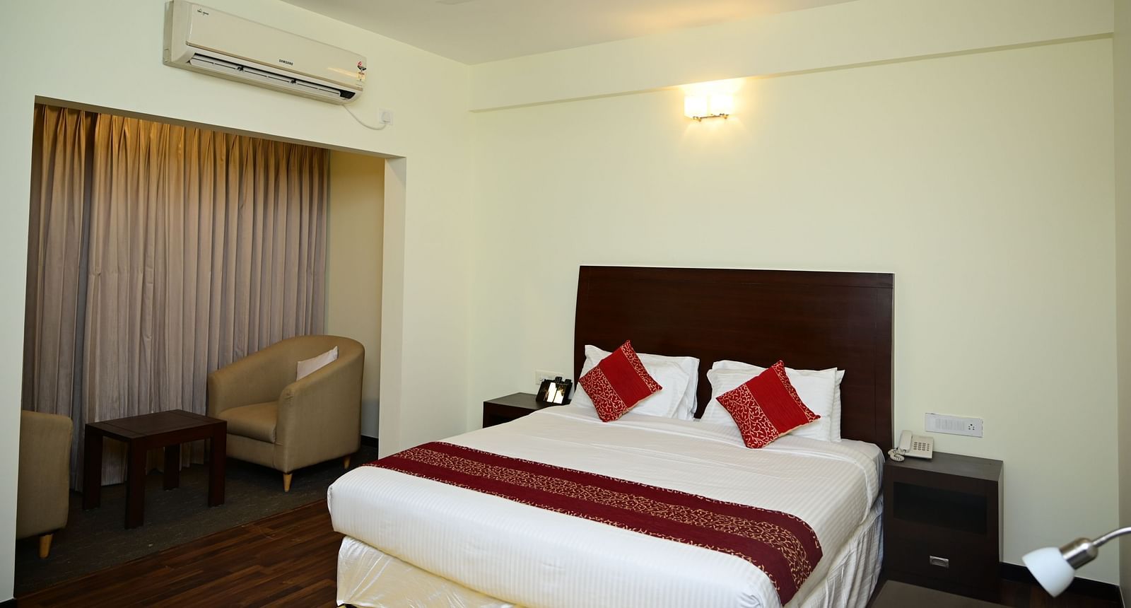 A double bed with red blanket and red pillow covers in the Executive Suite at Sterling Keys by TGI 1
