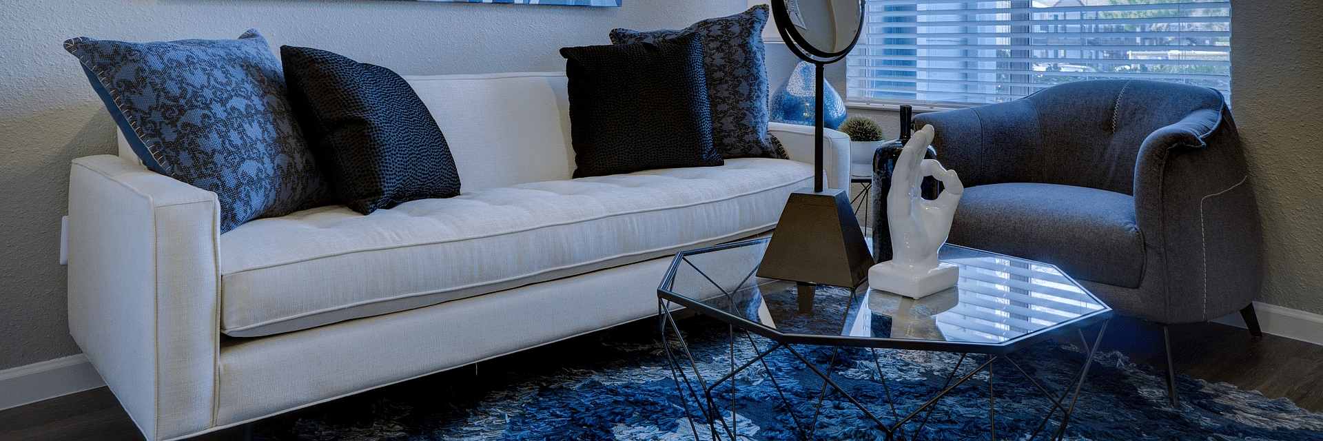 A modern living room with a sofa, artwork, and a window.