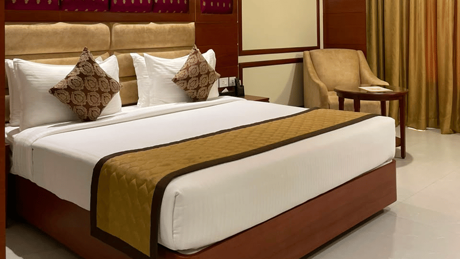 A room with a large bed, sheets, pillows, and curtains. | MM Legacy, Kanchipuram