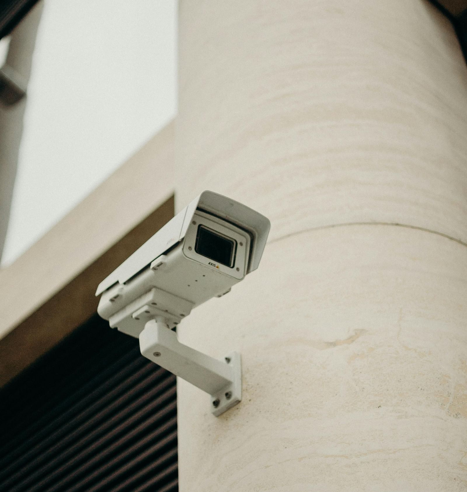 A close-up shot of a CCTV camera attached to a concrete pillar.