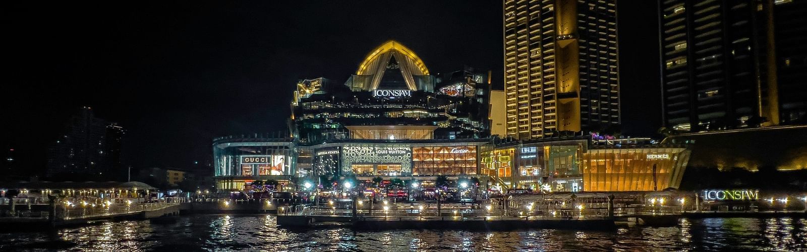 An overview of Chao Phraya River in the night with Iconsiam in view.