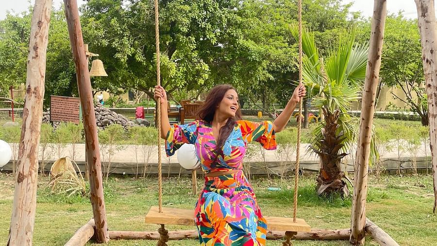 a woman on a swing at Themis Mudhouse - A Nature's Retreat Resort & Wellness