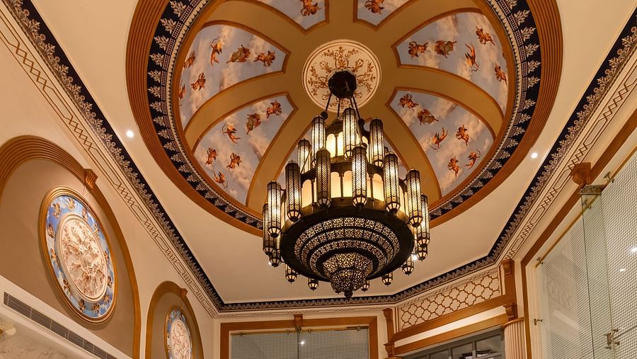 Hotel reception area with a desk, chairs, and a beautiful chandelier on the ceiling
