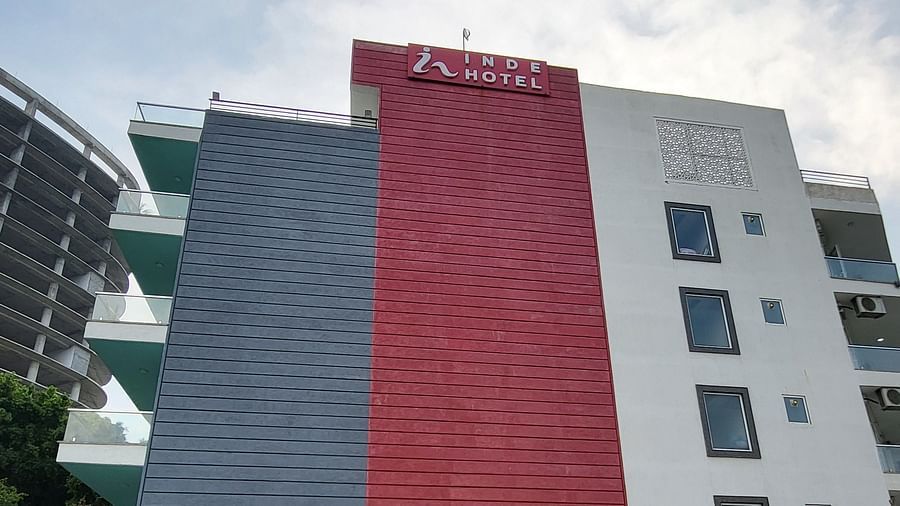 A facade image of Inde Hotel Golf Course extension featuring multiple storeys, balconies on each floor and a lawn in front of the property