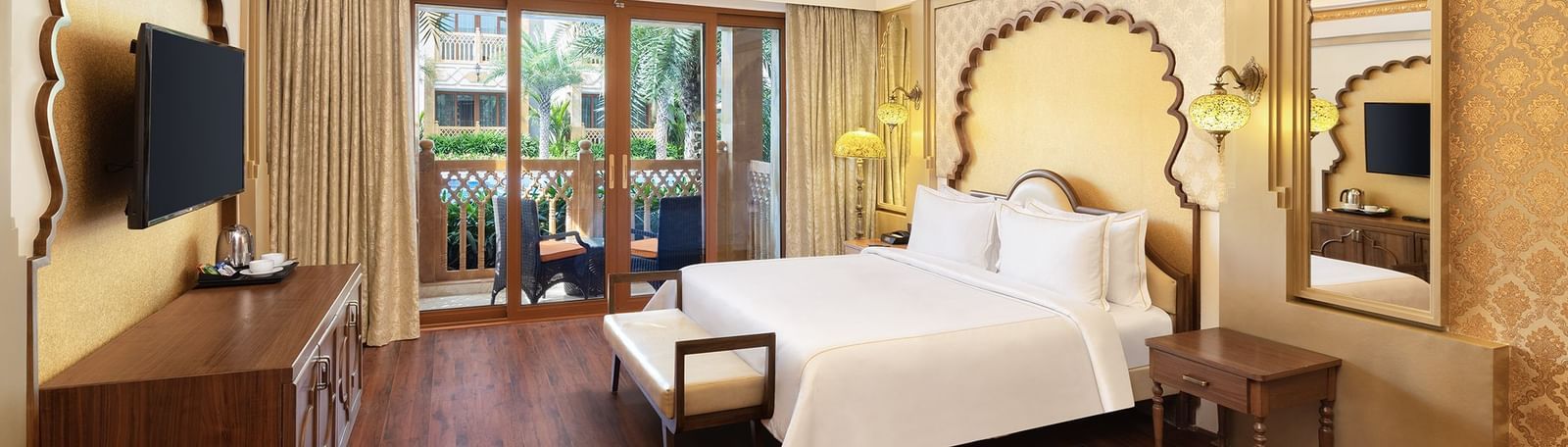 An elegant bedroom with a canopy-styled headboard and artistic wall panelling – Kaldan Samudra, one of the finest Mahabalipuram resorts with private beach