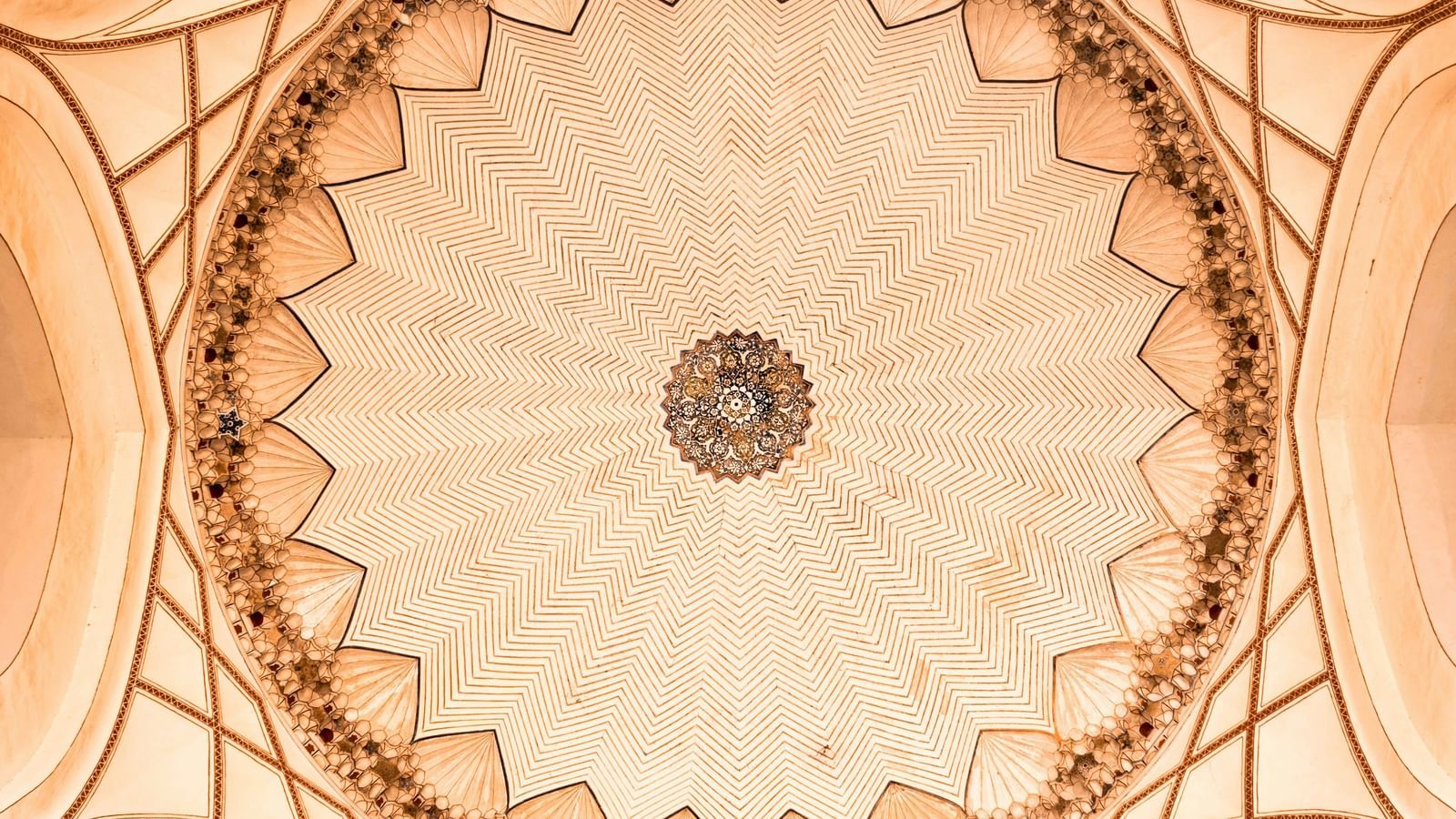 a view of the dome from below with intricate architecture in the mughal period