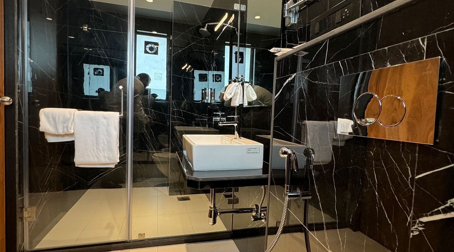 Overview of the bathroom with a glass door for the shower area inside luxury room - Hotel Mumbai House, Valnai, Malad